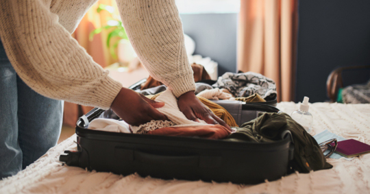 woman unpacking her things from a suitcase at home